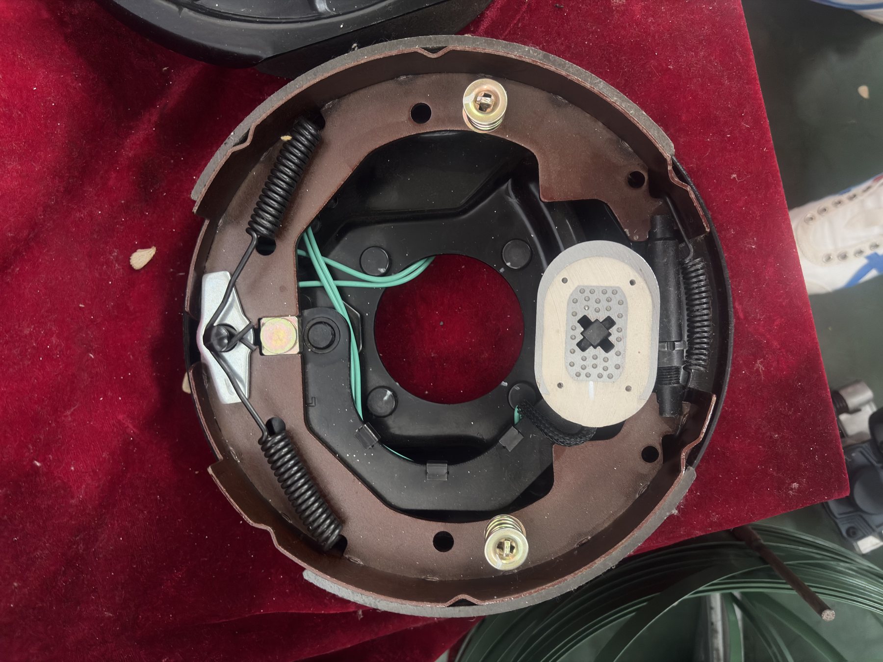 Loaded brake backing plate sample showing shoes springs adjuster magnet and wiring